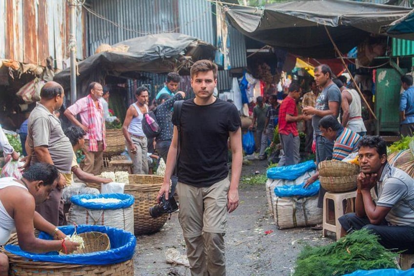 A crowded market with people selling and buying goods, including baskets and bags. 3