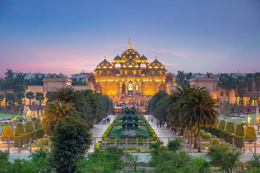 A temple with golden domes, surrounded by well-manicured gardens and palm trees. 1