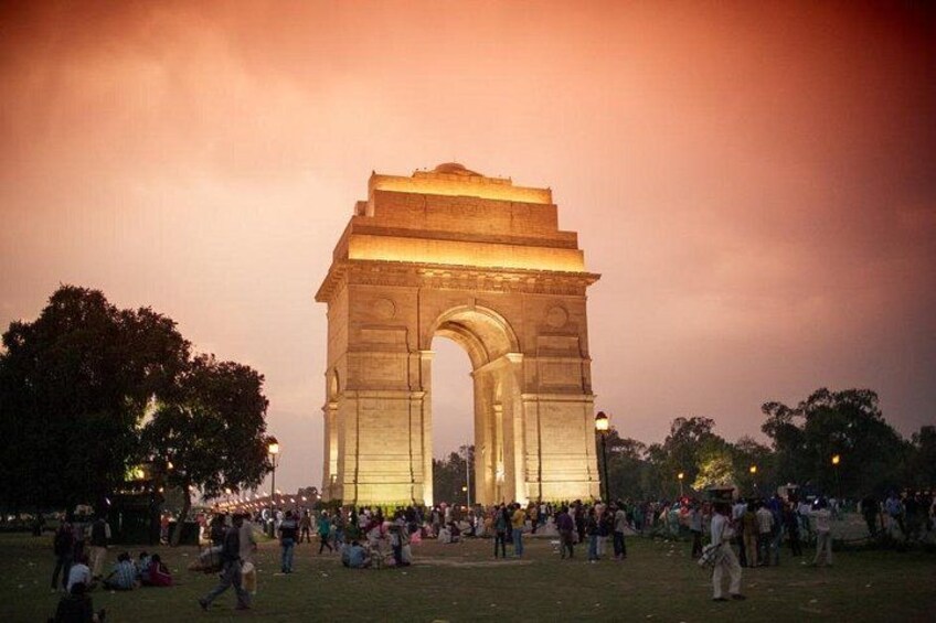 A large, illuminated arch structure with people gathered around it. 2