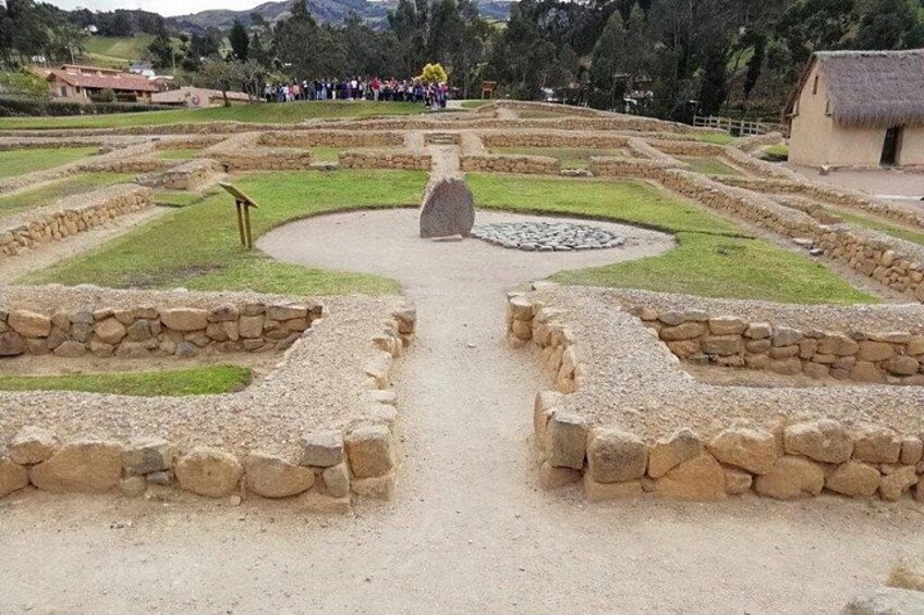 Un sitio histórico con senderos de piedra y una estructura central de piedra. 2