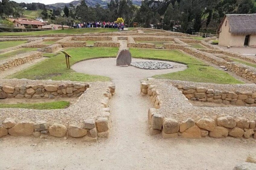 A historical site with stone pathways and a central stone structure. 4