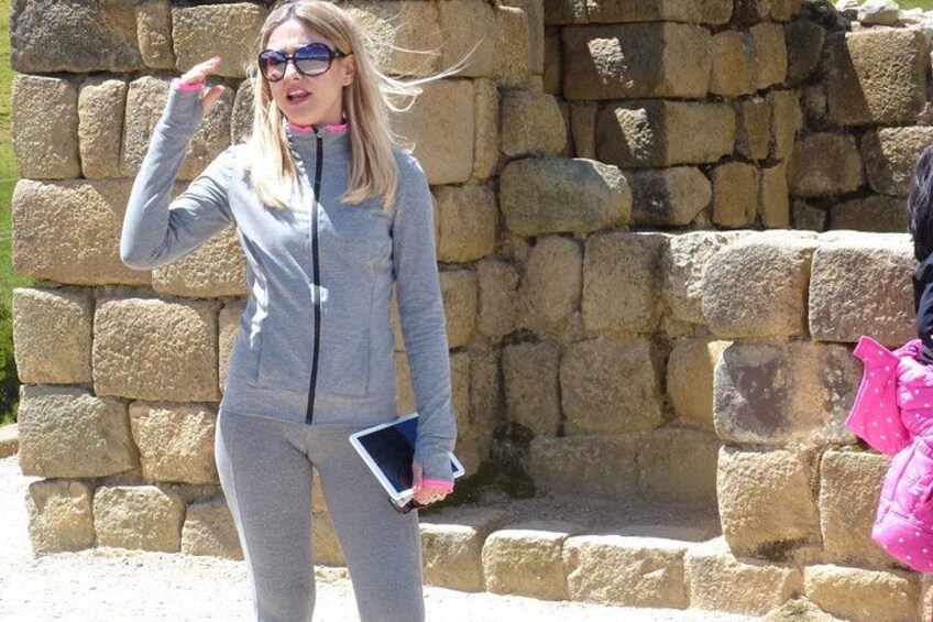 A person in a grey tracksuit standing in front of a stone wall. 5