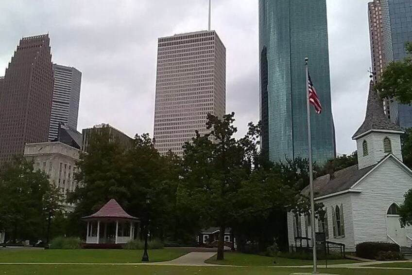 A cityscape with tall buildings, a gazebo, and a church. 2