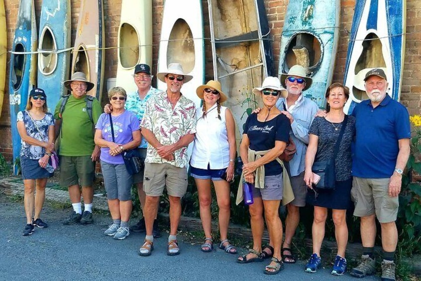 A group of people standing in front of a row of kayaks. 3