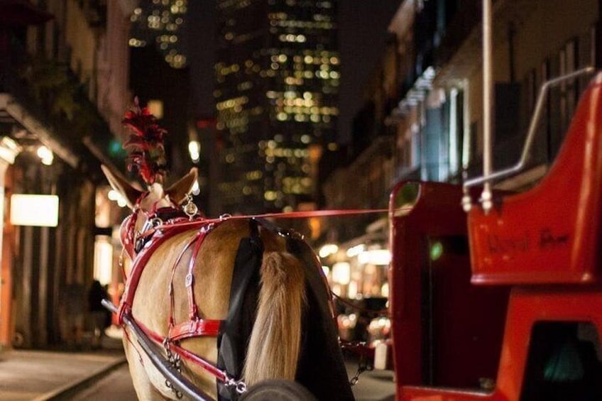 A horse-drawn carriage on a city street at night. 2