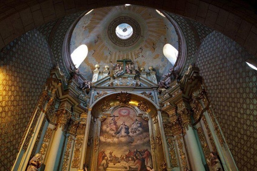 An ornate church interior with a large dome, frescoes, and detailed gold decorations. 2