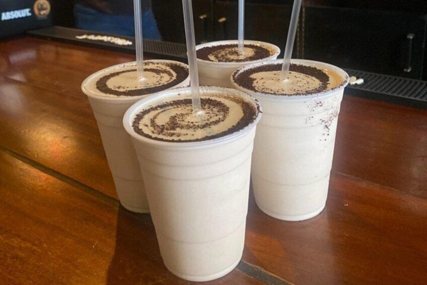 Tres tazas blancas de plástico con remolino de chocolate, sobre una superficie de madera. 2