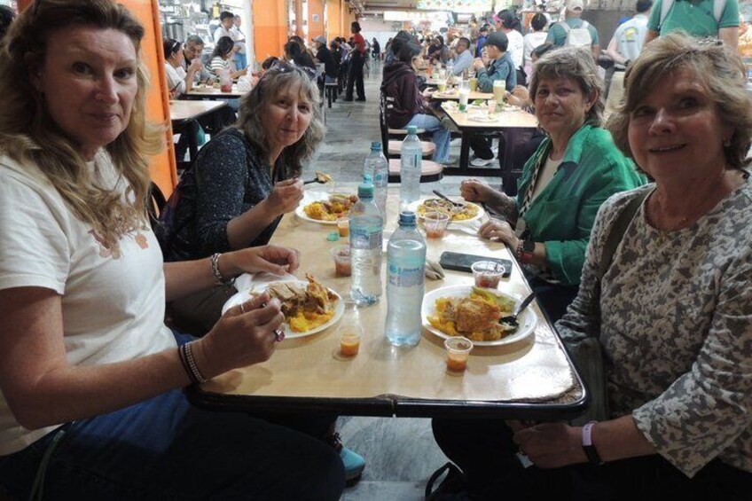 A group of people dining at a cafeteria with tables and chairs. 3