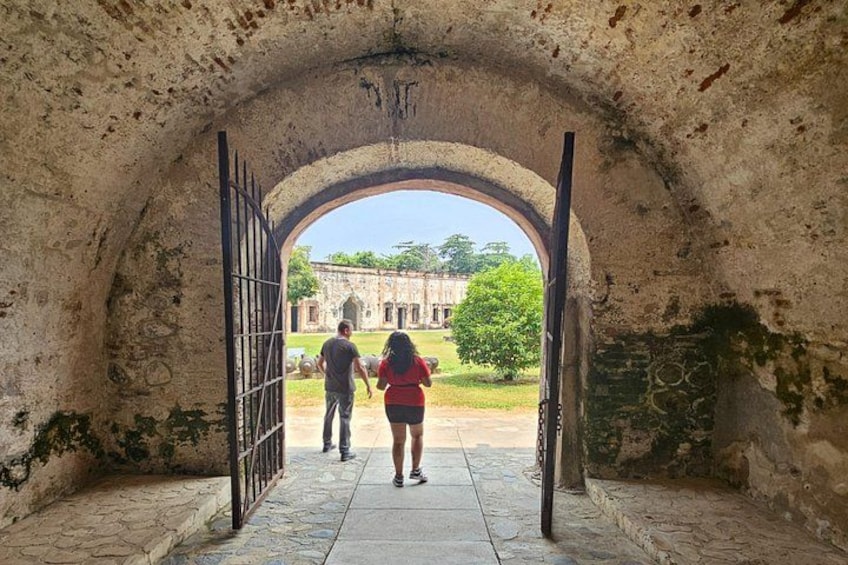 An arched doorway leading to a courtyard with a building in the background. 5