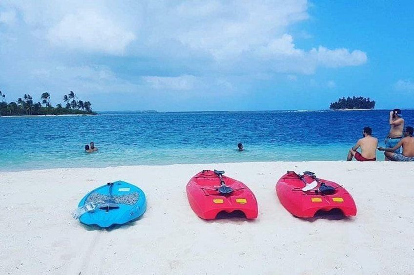 Une plage avec trois kayaks, un rivage sablonneux et l’océan en arrière-plan. 1