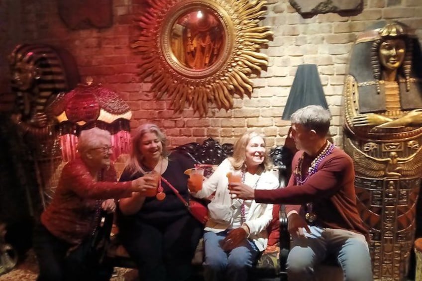 Un grupo de personas sentadas en un sofá en una habitación con decoración egipcia. 2
