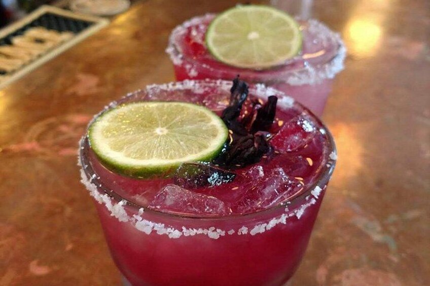Two glasses of red beverage with lime slices and a garnish, served with ice. 3