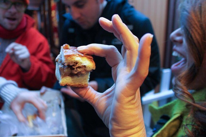 A person holding a sandwich with a visible filling. 2