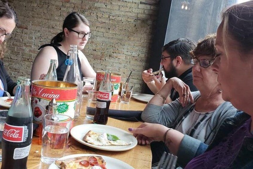 People dining at a table with food, drinks, and a bottle of Coca-Cola. 5