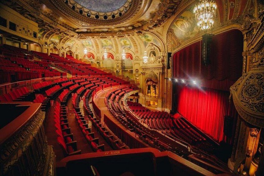 Ein prächtiges Theater mit roten Sitzen und einem roten Vorhang. 4