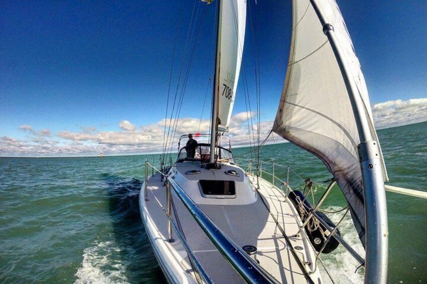 A sailboat with a white sail and the number 708 on it, sailing on the water. 4