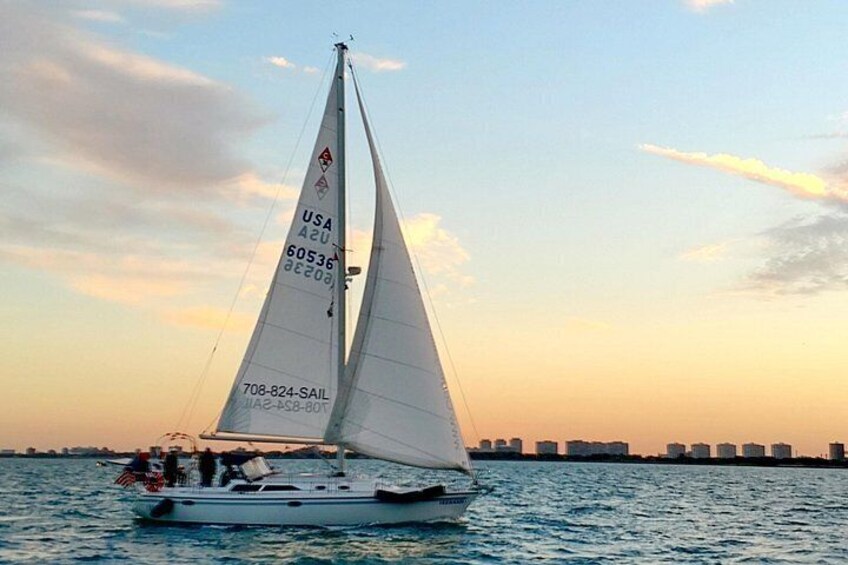 A sailboat with a white sail, USA registration number 60536, sailing on calm water. 3