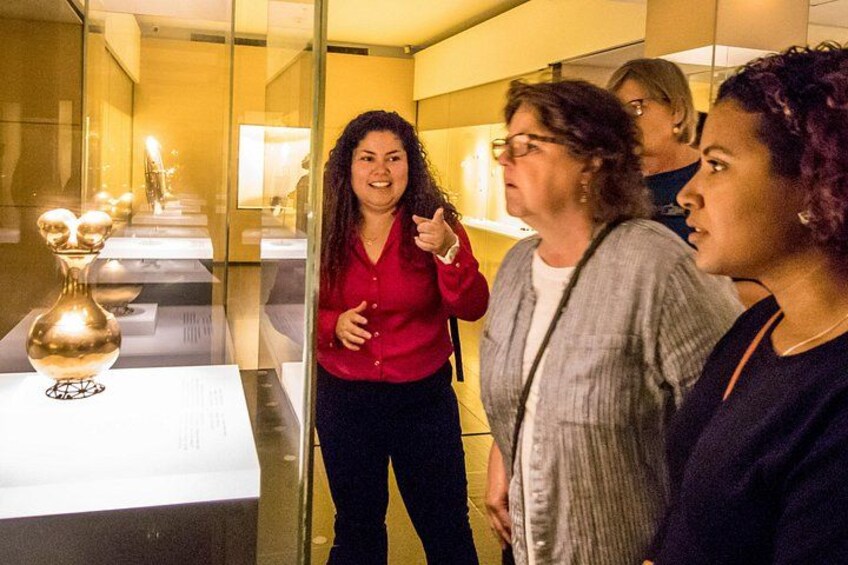 Ein Museuminneres mit Glasvitrinen und einer goldenen Skulptur. 3