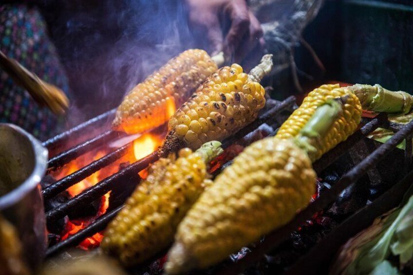 Street food vendor prepares corncobs on a char coal grill on Septimazo Avenue in Bogotá, Colombia.