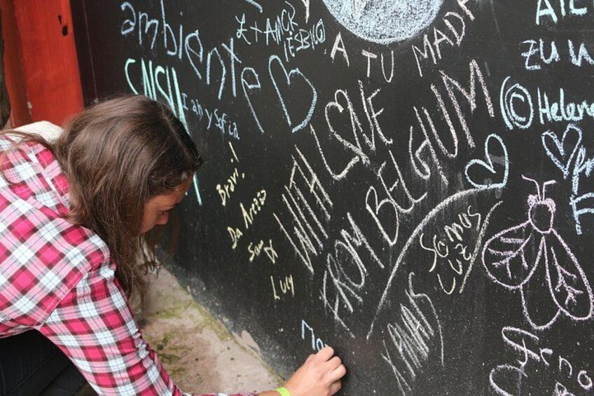 A person writing on a chalkboard with various words and phrases. 3