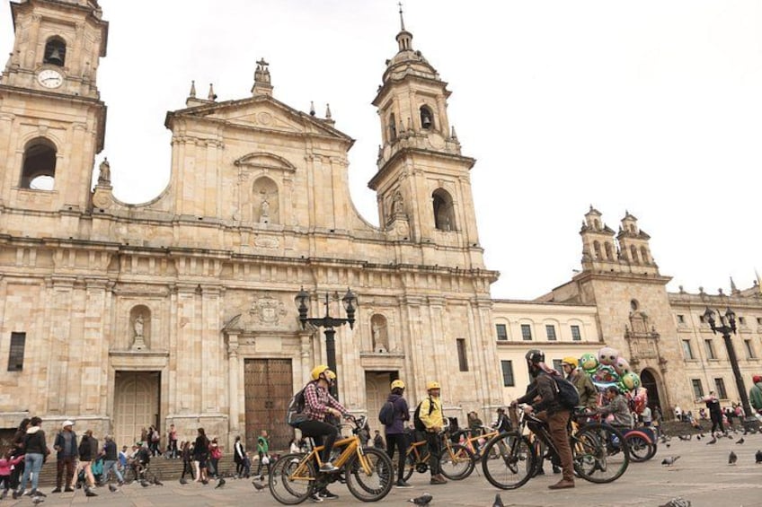 A historic cathedral with two bell towers, surrounded by people and bicycles. 1