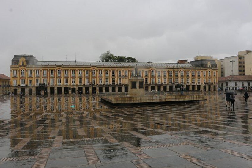A historic building with a tiled courtyard reflecting the structure. 3