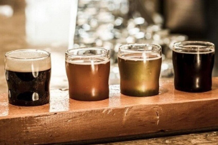 Four glasses of beer on a wooden surface. 4