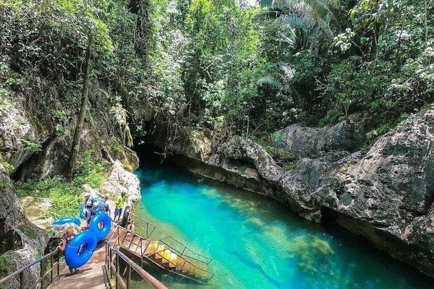 Une rivière turquoise, bordée d’une végétation luxuriante et de falaises rocheuses. 1