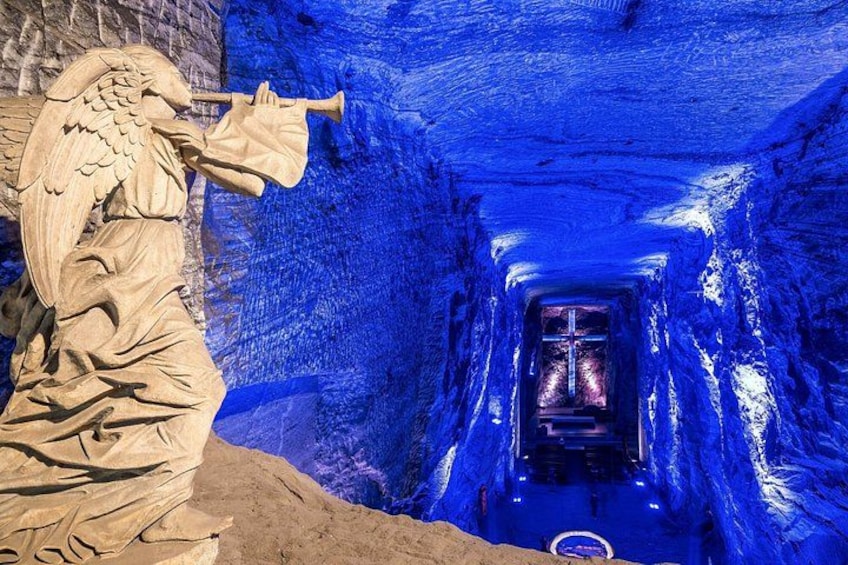 A statue of an angel with a trumpet, a tunnel with blue lighting, and a cross at the end. 3