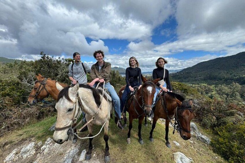 Four people on horseback in a natural landscape with mountains in the background. 5