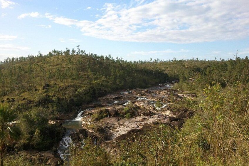 En flod som flyter genom ett bergigt landskap med tät skog på sluttningarna. 5