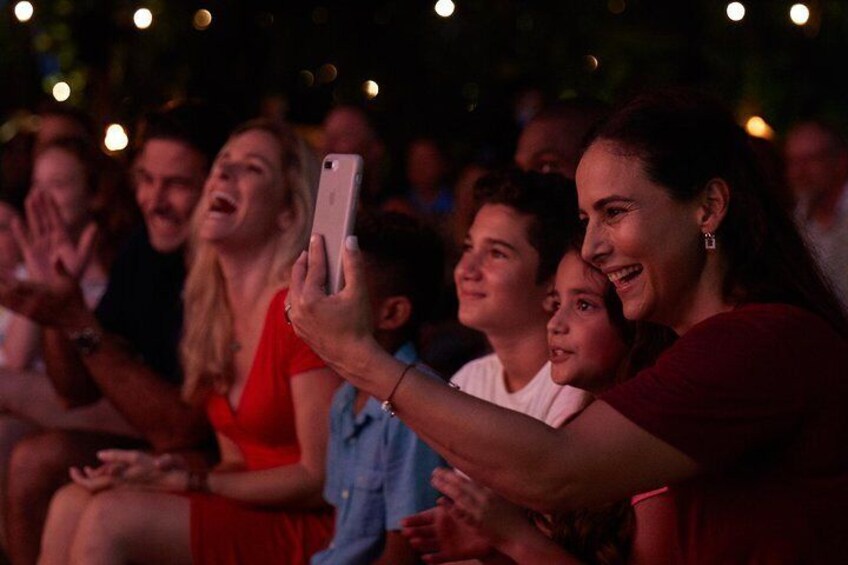 Een persoon die een smartphone vasthoudt, zittend tussen een groep mensen. 3