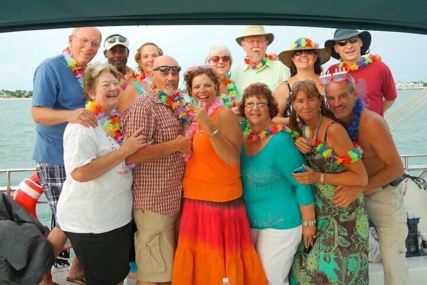 A group of people on a boat wearing leis and casual summer clothing. 3