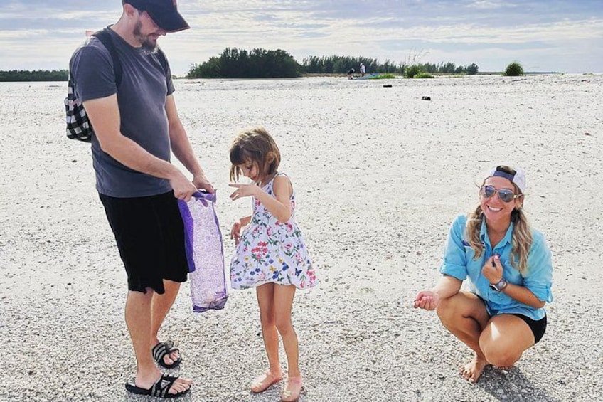 Una playa con gente, incluyendo un hombre, un niño y una mujer agachada. 4