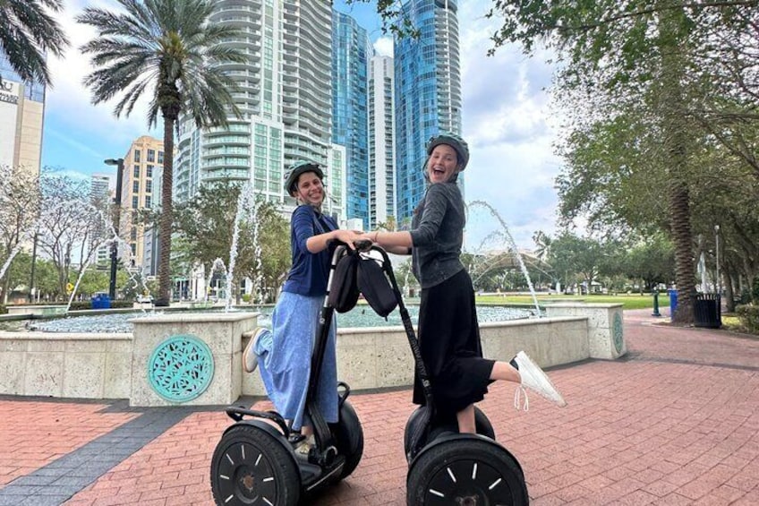To personer på Segway i en park med palmer og en springvand. 3