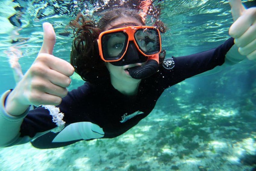 Una persona bajo el agua haciendo el gesto de pulgar hacia arriba. 4