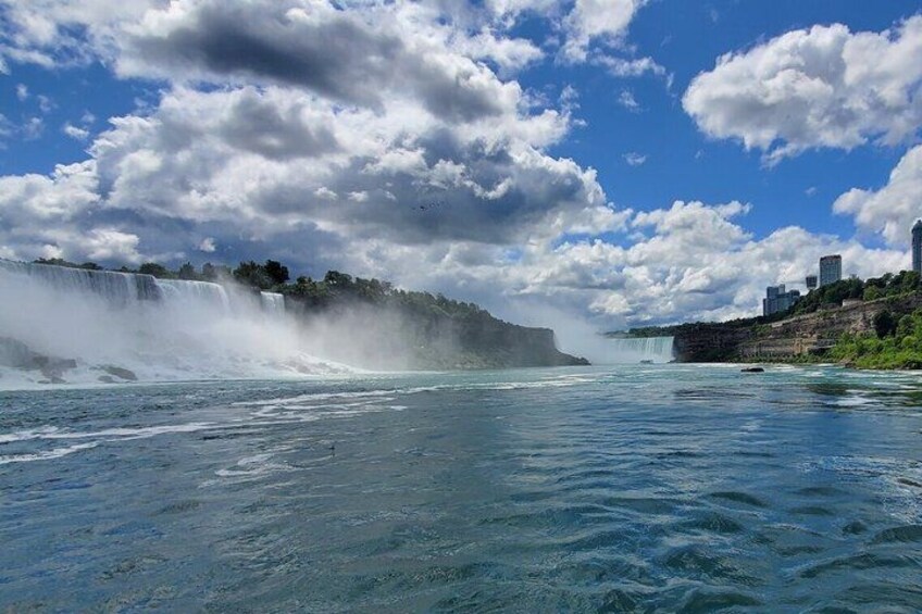 Una cascata, acqua cristallina blu e sullo sfondo la skyline di una città. 2