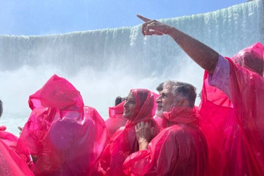 People in pink rain ponchos near a waterfall. 3