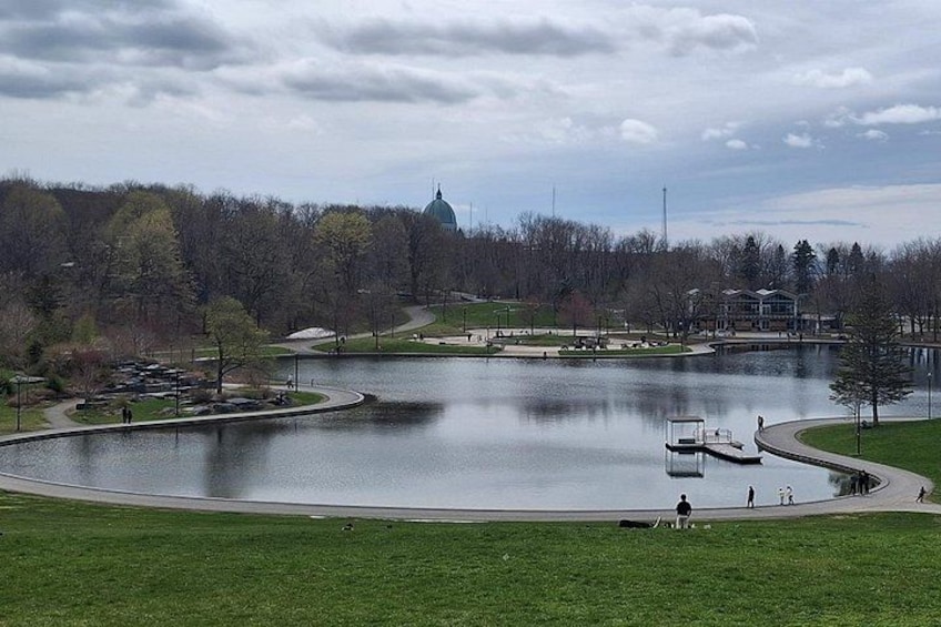 A lake with a dock, a grassy area, and a building in the background. 2