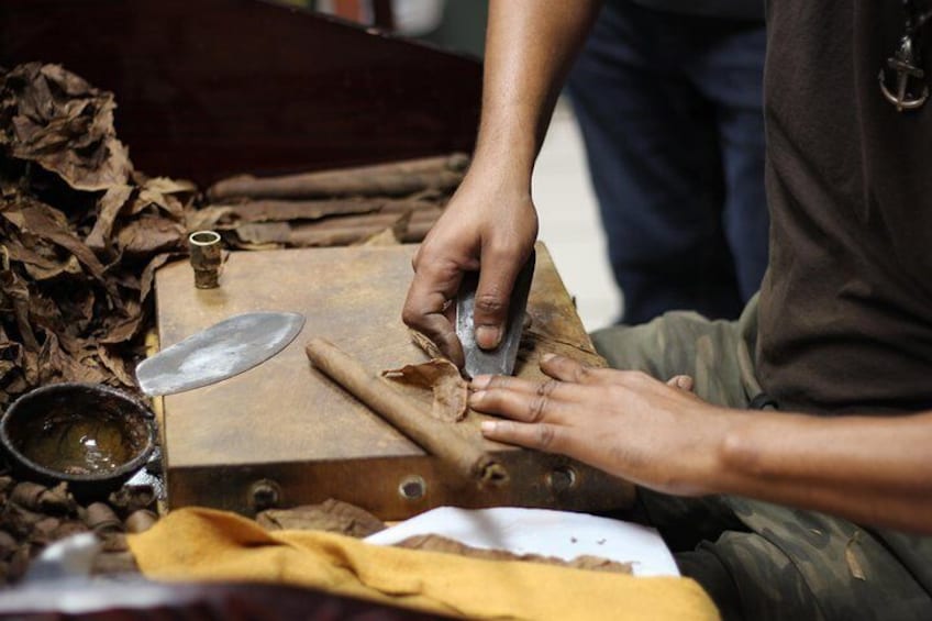 Una persona taglia legno con un coltello su un banco da lavoro. 5
