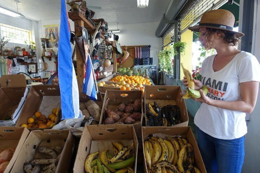 A woman at a market stall with boxes of fruits and vegetables. 4