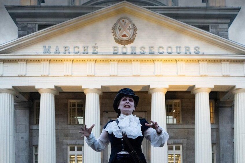 Una persona vestida con traje histórico frente a un edificio con columnas y la inscripción 'MARCHÉ BONECOURS'. 2