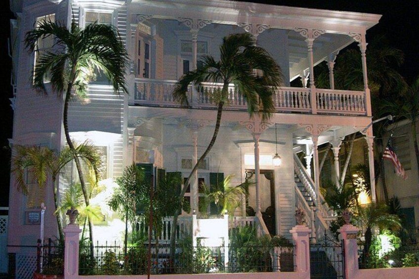 A multi-story building with balconies, palm trees, and a staircase. 1