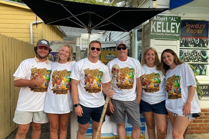 A group of people standing in front of a jewelry repair shop. 2