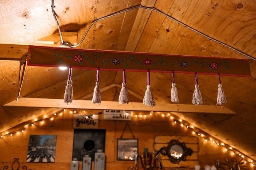 Un plafond en bois agrémenté d’une poutre décorative, de glands et de guirlandes lumineuses. 2