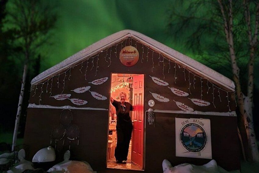Une cabane en bois avec une enseigne indiquant « Motel » et une personne debout devant la porte. 3