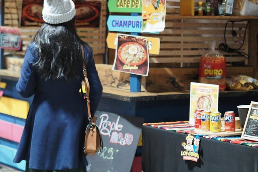 A person at a food stall with a sign for 'Cafe de Champuri' and 'Duro' sauce. 3
