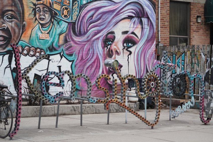 Un mural que muestra una bicicleta y una cerca. 2