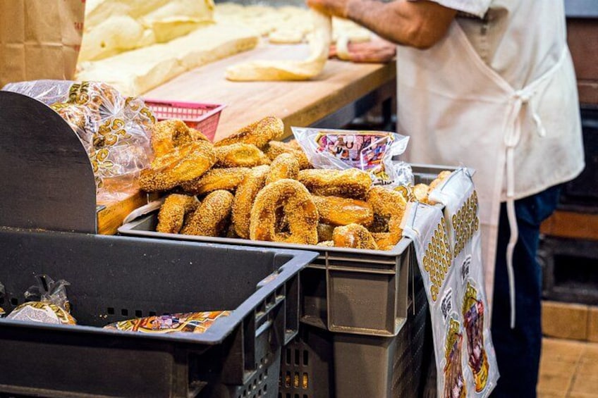 A food stall with fried doughnuts and a person wearing an apron. 2