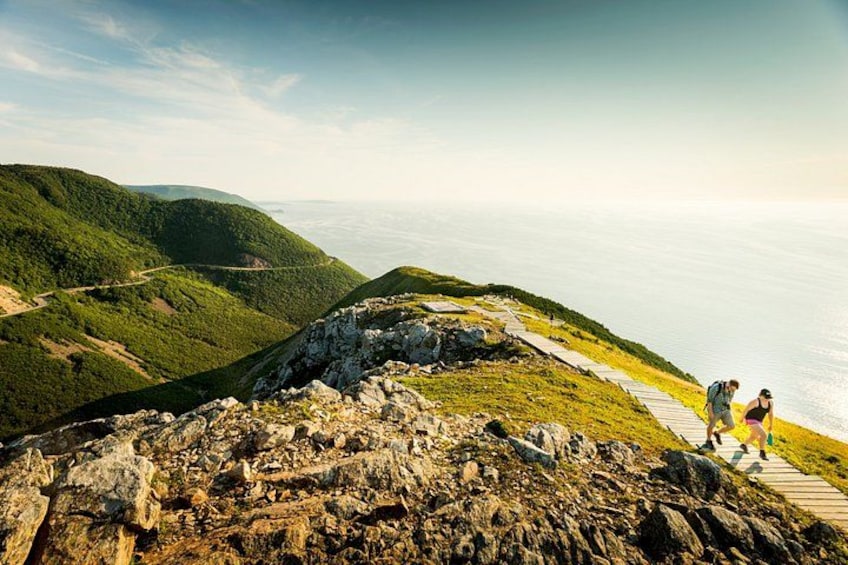 A hiking trail on a mountain with a view of the ocean. 4